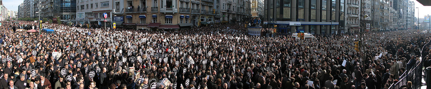 Der Trauerzug mit fast 100.000 Menschen auf der Halaskargazi-Straße, wo sich auch der Sitz der Zeitung Agos befindet (das Gebäude ganz rechts im Bild, an dessen Fassade ein großes Hrant-Dink-Plakat angebracht ist)