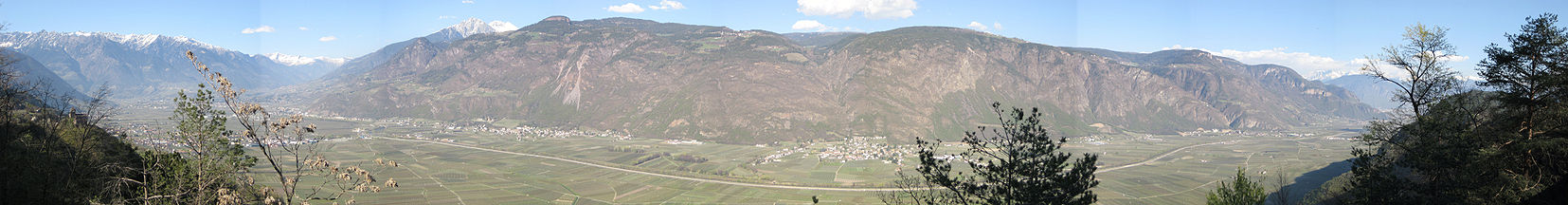 Blick von Westen über das Etschtal zwischen Meran und Bozen. Der Steilabfall zum Tal besteht aus Vulkaniten, obenauf lagernd die Gröden-Formation und Werfen-Formation