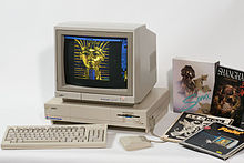 Foto: Amiga 1000 mit Monitor, Tastatur und Maus, daneben vier Software-Verpackungen