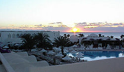Sonnenaufgang am Meer vor einem Ferienhotel auf Djerba