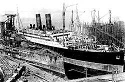 Die RMS Andania neben der HMS Ajax