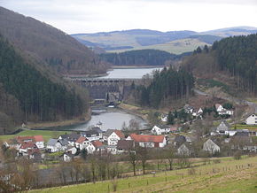 Diemeltalsperre. Staumauer mit See, Ausgleichsweiher und Kraftwerk. Im Vordergrund die Ortschaft Helminghausen. Links der Eisenberg.
