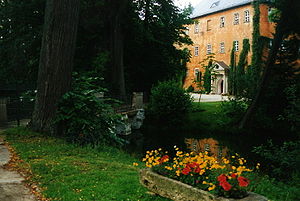 Frontansicht des Wasserschlosses Weißdorf mit Wassergraben und Eingangsportal