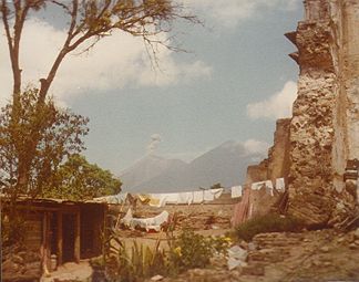 Hütte in den Ruinen eines spanischen Kolonialgebäudes in Antigua, mit dem Volcán de Fuego (links) and Acatenango (rechts) im Hintergrund.