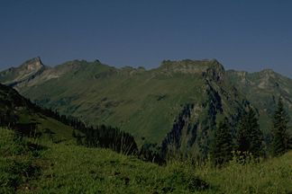 Berggächtle (Der linke Eckpunkt des annähernd gleich hohen Grates) vom Roßkopf. Rechts davon (Der Berg über der linken der drei Fichten am rechten Bildrand) der Giebel. Ganz links am Bildrand der Schneck.