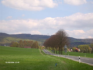 Der Hohe Hagen von Scheden aus gesehen. Im Vordergrund die B 3.