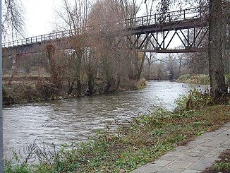 Rednitz bei Fürth-Weikershof; darüber die einspurige Eisenbahnbrücke der Bibertbahn; hinter der Brücke sind Tore einer Wildwasserstrecke für Kanu/Kajak zu sehen