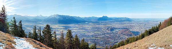 Blick nach Westen, über das Salzburger Becken und die Stadt mit ihren Stadtbergen um den historischen Kern, gegen Untersberg und Hochstaufen