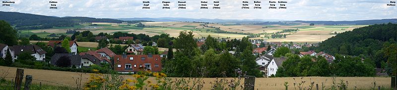 Blick von der Weinstraße auf Goßfelden, die Wetschaft-Senke und das Rothaargebirge;gut erkennbar von links nach rechts der Wollenberg (474 m), der Kohlenberg (583 m), die Ziegenhelle (816 m), der Heidekopf (704 m), der Bollerberg (757 m), der Reetsberg (792 m), der Schloßberg (790 m) und der Burgwald mit Burg Mellnau